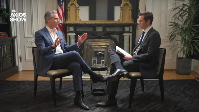 Gov. Gavin Newsom talks to Axios' Alex Thompson. Two men in suits in chairs.