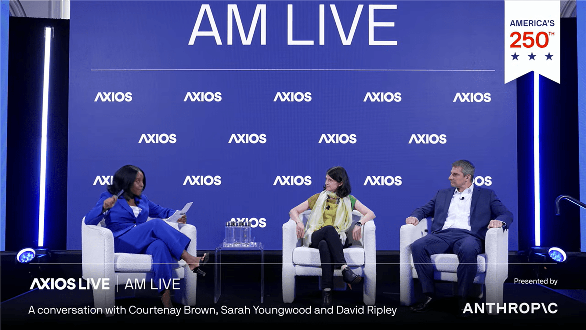 Three speakers sit onstage during an Axios AM Live event. Courtenay Brown, at left, moderates a conversation with Sarah Youngwood of Nasdaq and David Ripley of Kraken against a blue Axios-branded backdrop sponsored by Anthropic.